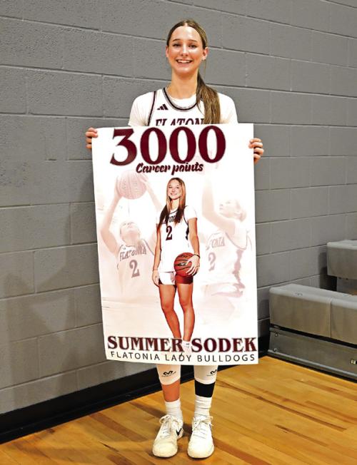 Flatonia’s Summer Sodek holds up a banner after Tuesday’s game to celebrate scoring 3,000 career points. Photo by Stephanie Steinhauser