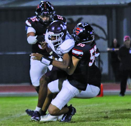 Schulenburg’s Dean Bradley (#55) and Jayden Olmos (#50) bring down Flatonia quarterback Jaylon Anderson Friday. Photo by Audrey Kristynik