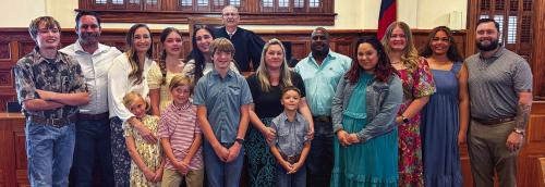 The Greenwood, Jackson and Ellis families pose for a photo graph with District Judge Jeff Steinhauser following proceedings last Thursday, May 28. Photo by Andy Behlen