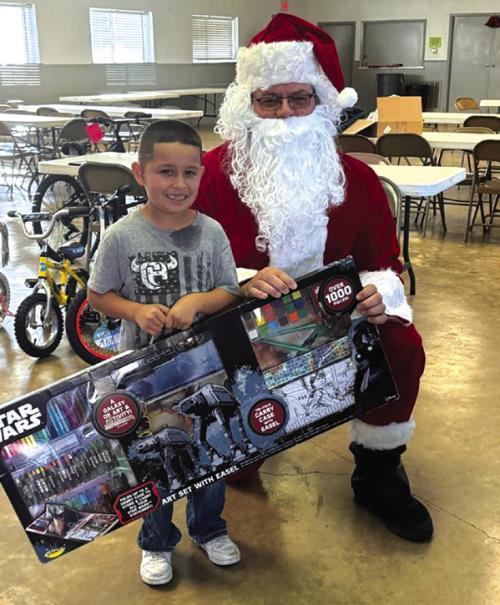 A local child with his present from Santa at a Deputy Santa pick-up location last year.