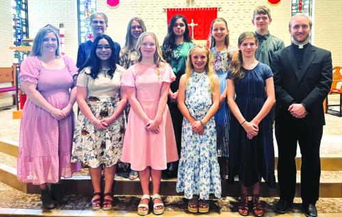 Sacred Heart Catholic School 2022-2023 sixth grade graduates exhibit the SHS motto “Enter to Learn, Exit to Lead.” Pictured are (front, from left) Mrs. Laura Elliott, Eliana Anzaldua, Lyria Hartley, Abby Cernosek, Makenna Emmel, and Fr. Brian Phillips, (back row) Mrs. Cathy Zingelmann, Kenlie Kallus, Lilly Bell, Lyla Cowen, and Aiden Harbers.