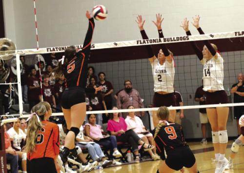 SHS’s Haylee Vacek spikes Tuesday against the block of Flatonia’s Summer Sodek and Quinn Arnett. Photo by Audrey Kristynik
