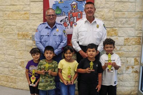 Fire poster winners from the Pre-K and Kindergarten class at La Grange Elementary are (front, from left) Victoria Gugjardo-winner, Leonardo Rodriguez-honorable mention, Analia Mata-winner, Ivan Reveles-honorable mention, and Izaiah Luna-winner. Also pictured are Captain Kenneth Chovanec and Fire Chief Frank Menefee of the La Grange Volunteer Fire Department.