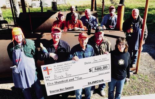 The Holy Smokers January cook benefited the Bugle Boy. Pictured (back, from left) are: Chuck Gibson, Guy Mason, Paul Cheatham, Bill Bailey, Larry Kahanek, and Ed Dykes, (front) Paul Crane, Weldon Koenig, Dan Boyles, Mike Parrish, and Heather Allbright, Executive Director of The Bugle Boy.