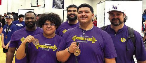 Left to right at regional powerlifting for La Grange – Coach Nick Parker, Erick Guevara with his second place medal, coach Frankie Saucedo, Javier Cuevas with his fourth place medal, and head coach Charles Otto.