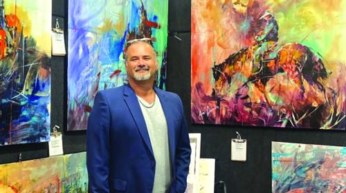 Jeremy Serna in front of some of his work.