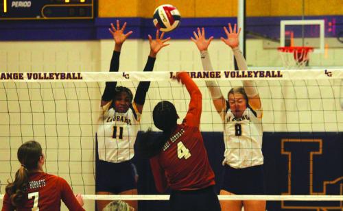 La Grange’s Brion Williams, left, and Carley Ulrich, right, jump to try to block this Caldwell hit Friday. Photo by Jeff Wick