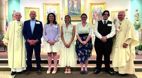 Welcoming new converts at St. John from left: Deacon Robert Jasek, Matthew Woods, Sara Bull, Allyson Campos, Caroline Davis, Zackry Meier, and Pastor Steve Sauser.