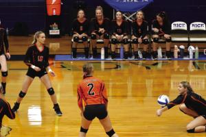 As her teammates look on, Schulenburg’s Haylee Vacek digs a ball in Tuesday’s victory at Rice Consolidated.