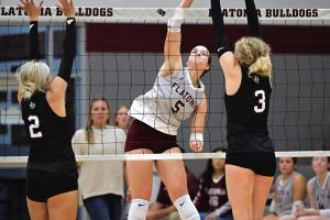 Flatonia’s Abbie Uzzell spikes a ball between Fayetteville players Aubree Graeter, left, and Scotti Beseda, right. Photo by Stephanie Steinhauser