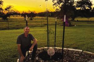Jason McBroom with the Monterrey Oak planted in his front yard.
