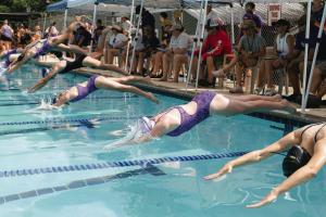 Swimmers dive into the water at the beginning of their first home meet Saturday at Camp Lone Star. Photo by Brittany Dawson