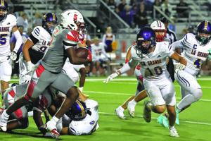 La Grange’s Koen Zbranek, 10, tries to close in on Bellville running back Travis Turner, who scored five touchdowns and ran for 250 yards Friday. Photo by Darrell D. Gest