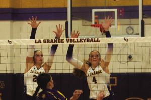 La Grange’s Kyndal Brawley, left, and Avery Griffin, right, jump to try to block a Weimar hit in Tuesday’s win. Photo by Jeff Wick