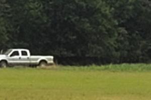 Members from the Austin County Special Response Team, right, approach the stolen vehicle and trailer, left, Wednesday off Old Plum Highway and Egypt Road.