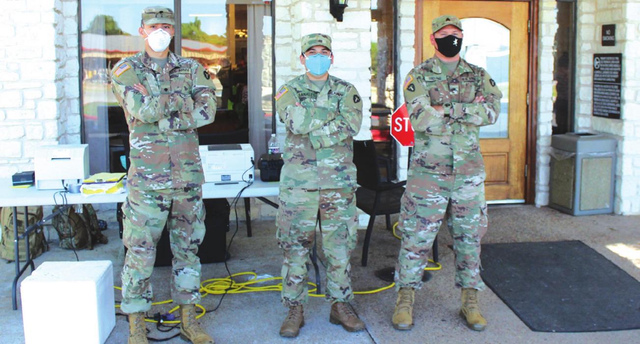 Three members of the National Guard pause from their duties Friday during a mass testing event at Monument Hill Nursing Home in La Grange. They had been doing the same thing in Bastrop the day before. Photo by Jeff Wick
