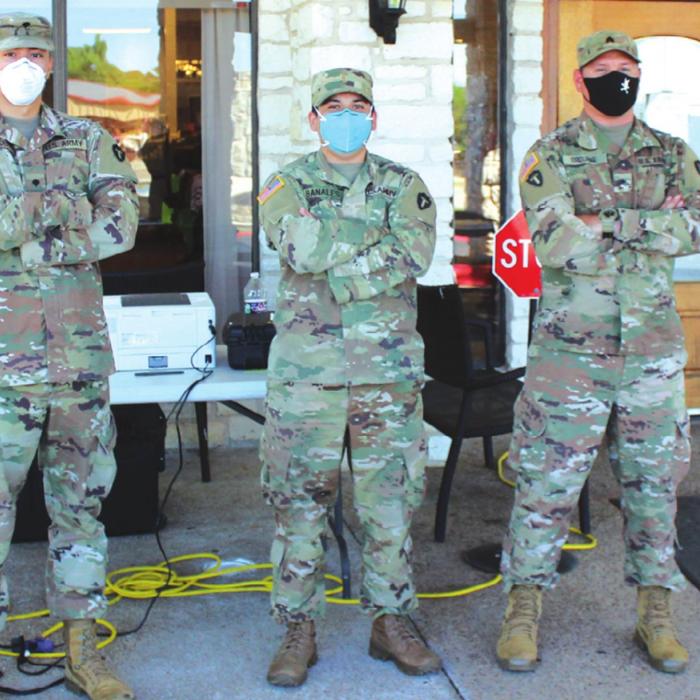 Three members of the National Guard pause from their duties Friday during a mass testing event at Monument Hill Nursing Home in La Grange. They had been doing the same thing in Bastrop the day before. Photo by Jeff Wick