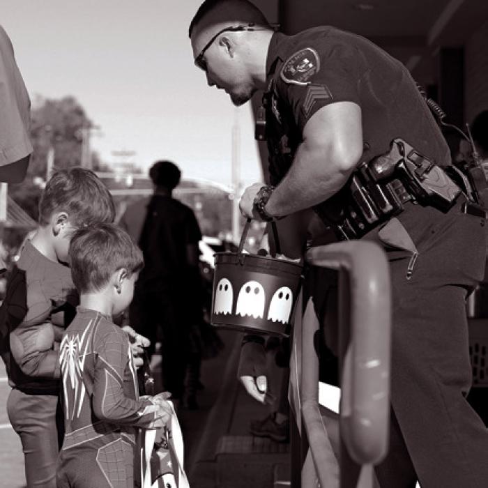 La Grange police officer Mitchell Maxwell hands out candy during the trick-or-treat on the square event that drew thousands Thursday.