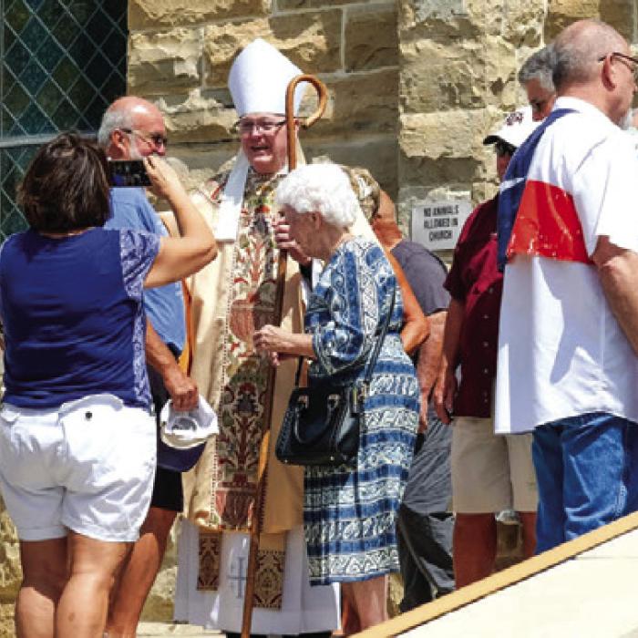 Bishop Brendan Cahill greets the faithful after Mass during the Praha Picnic on Saturday.