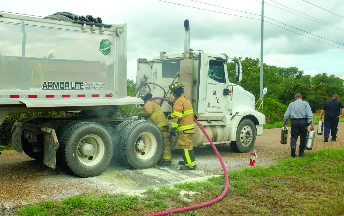 La Grange firefighters use water to cool down a set of brakes that locked up on an 18-wheeler Tuesday. The truck driver stopped on Von Minden Road in front of the Remnant Church around noon after noticing smoke coming from tires. “It didn’t actually catch on fire but it came real close,” said La Grange Fire Chief Frank Menefee. Photo by Andy Behlen