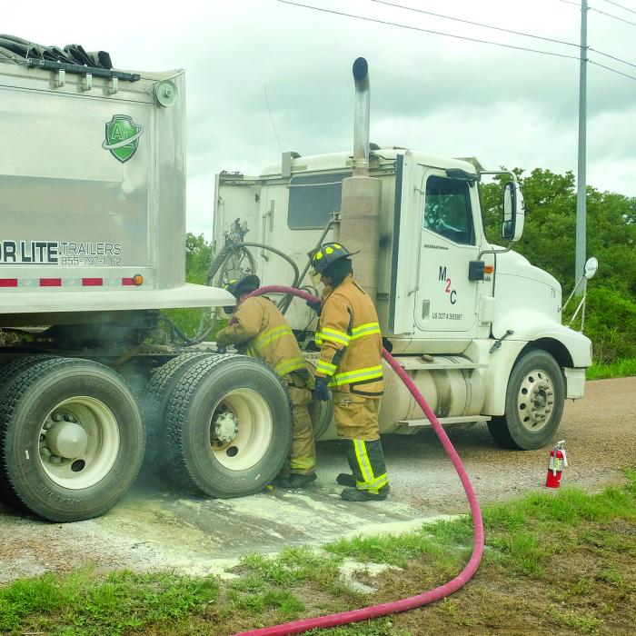 La Grange firefighters use water to cool down a set of brakes that locked up on an 18-wheeler Tuesday. The truck driver stopped on Von Minden Road in front of the Remnant Church around noon after noticing smoke coming from tires. “It didn’t actually catch on fire but it came real close,” said La Grange Fire Chief Frank Menefee. Photo by Andy Behlen