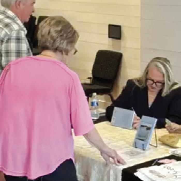 Author Sarah Bertsch at book signing in the community center.
