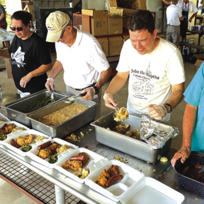 Church members load up the plates at last year’s Ammannsville church picnic, always on Fathers’ Day.