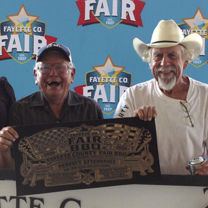 A Perfect Attendance Award was presented Saturday to Roger Brandt and Marty Brandt for their continued participation and support of The Fayette County Fair’s Bar-B-Q Cookoff. Roger has never missed a year of cookoffs (39 years and running) and Marty has participated in 36 consecutive cookoffs. Left to right are 2025 Queen second runner-up Keanna Henderson, Roger Brandt, Marty Brandt and 2025 Fair Queen Hailey Janish.