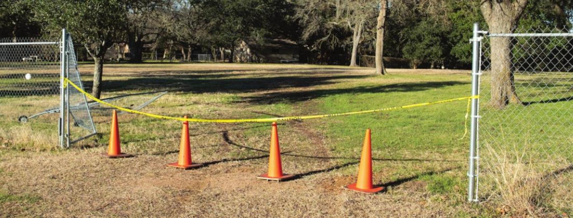 Orange cones and warning tape mark the spot where a car crashed through the fence and Monument Hill and Kreische Brewery State Historical Sites. Photo by Andy Behlen
