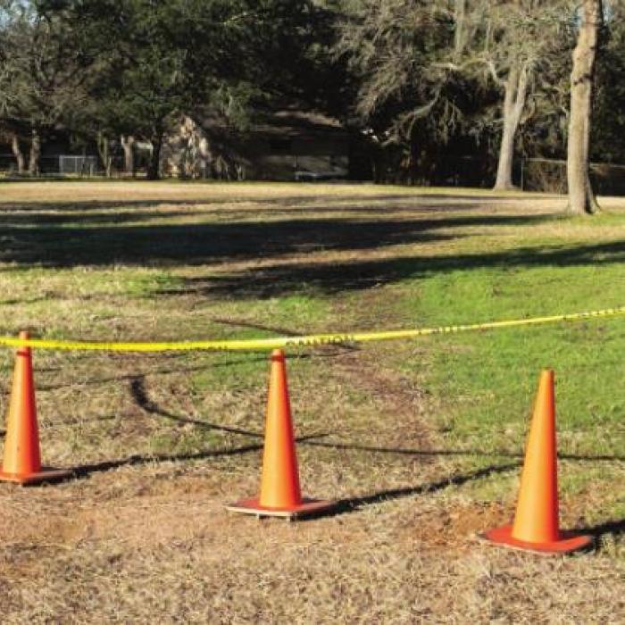 Orange cones and warning tape mark the spot where a car crashed through the fence and Monument Hill and Kreische Brewery State Historical Sites. Photo by Andy Behlen