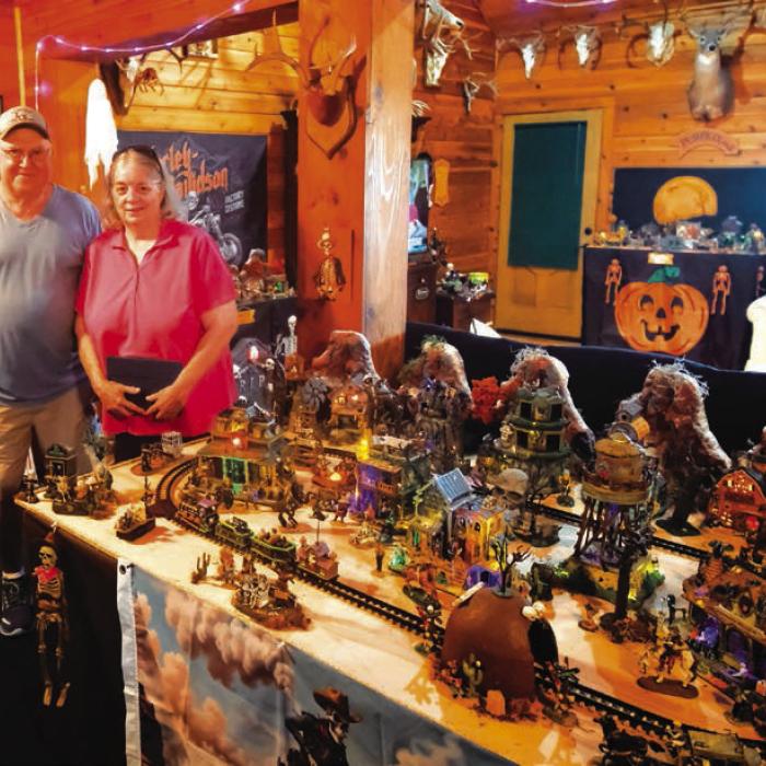 Tom and Denise Tofel next to one of their miniature villages featuring a spooky train track. Photos by Andy Behlen