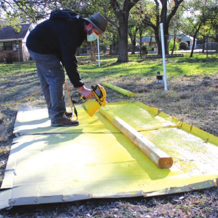 Allen Cooper is shown here Tuesday painting timbers to aid in the new parking set-up for the Trail of Lights.