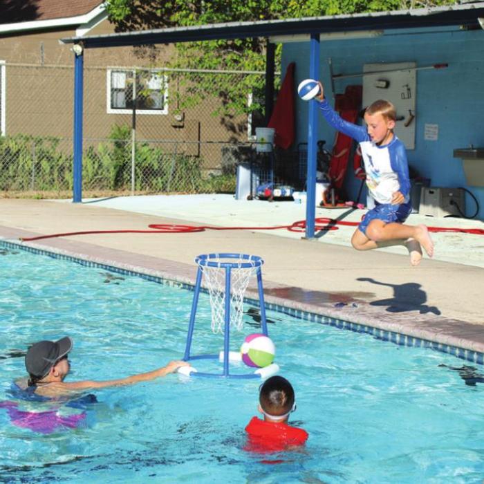K.K. Call jumps to slam dunk a ball in the pool.