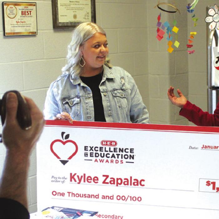 With cameras rolling Thursday, La Grange High School teacher Kylee Zapalac was informed she was a finalist for HEB’s Excellence in Education award and given a $1,000 check from Tamra Jones of HEB. Photo by Jeff Wick