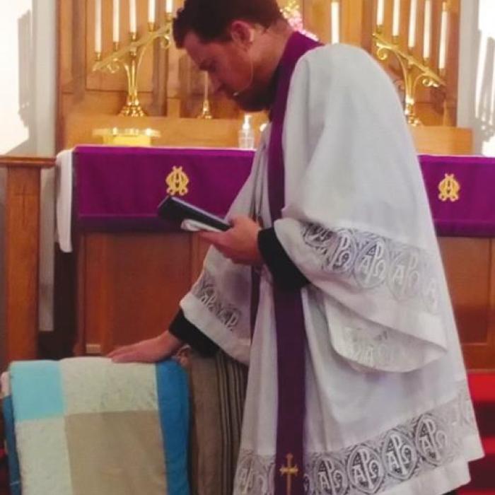Pastor Beck blessing the quilts.