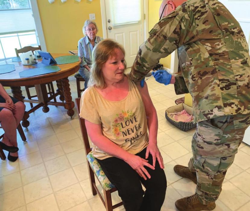 Staff Sgt. Joseph Stelker of the Air Force National Guard administers a coronavirus vaccine to Robin Lucadou of the Round Top area. Lucadou lost her husband to COVID-19 in January. Photo by Andy Behlen