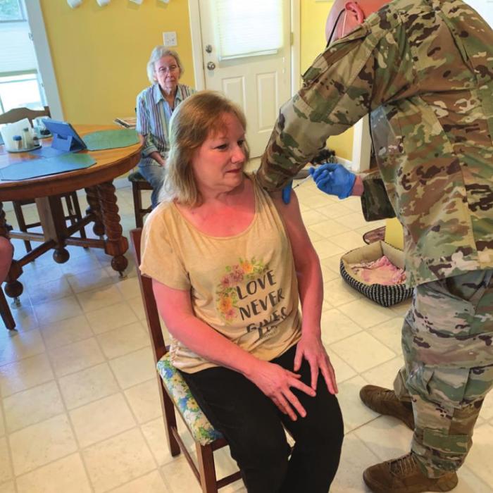 Staff Sgt. Joseph Stelker of the Air Force National Guard administers a coronavirus vaccine to Robin Lucadou of the Round Top area. Lucadou lost her husband to COVID-19 in January. Photo by Andy Behlen