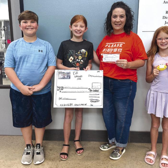Local students recently presented a $725 donation to the Gardenia E. Janssen Animal Shelter in La Grange after raising the money through a community lemonade stand. Pictured, from left, are Colby Walker, a fifth grader; Stevi Kadlecek, a fourth grader; Gardenia E. Janssen Animal Shelter Executive Director Tiffany Reid; and Landri Kadlecek, a third grader. Not pictured is Tucker Ming, a fourth grader, who also helped at the lemonade stand.