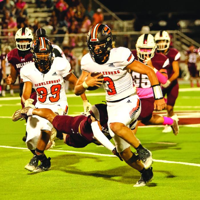 Schulenburg quarterback Aaron Janecek gets by a tackler Friday. Photo by Darrell D. Gest