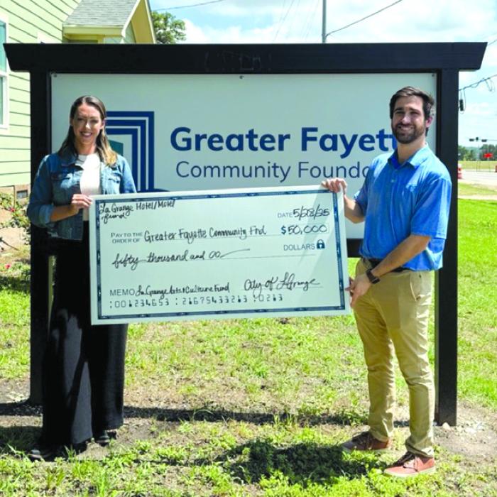 Susannah Mikulin, CEO of the Greater Fayette Community Foundation, and Caleb Parks, Main Street Manager for the City of La Grange, celebrate the check presentation together.