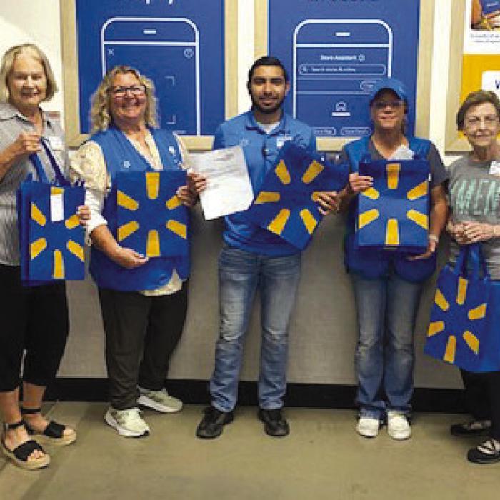 Walmart donated 100 reusable bags to AMEN. Pictured from left: Linda Oltmann, AMEN Board member; Reynea Gerdes, Walmart Associate; Roland Puga, Walmart Assistant Manager; Terry Muske, Walmart Lead; and Mary Vasek, AMEN Board member.