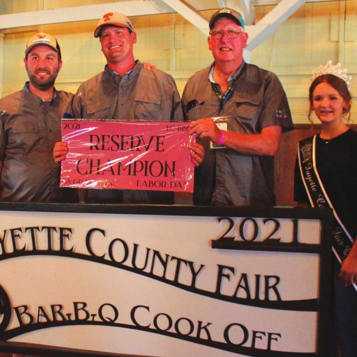 The Reserve Champion of this year’s Fayette County Fair Bar-B-Q Cook-Off was the “42 BBQ” team of La Grange which included Dennis Neuman, Tommy Neuman, Chris Neuman, Bryan Kerr and David Tofel. Also shown is Fayette County Fair Queen Charlee Wessels.