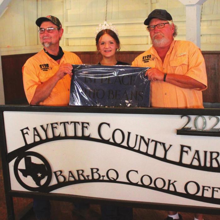 The Champion Beans this year’s Fayette County Fair were made by the BYOB Cooking Team of La Grange, which included Tim Machala and Charles Schulz. Also shown is Fayette County Fair Queen Charlee Wessels.