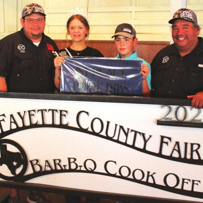 The Champion ribs at this year’s Fayette County Fair Bar-B-Q Cook-Off were made by CC’s Country BBQ of La Grange, which included Curt Harbers, Arthur Bosque and Clayton Johnson. Also shown is Fayette County Fair Queen Charlee Wessels.