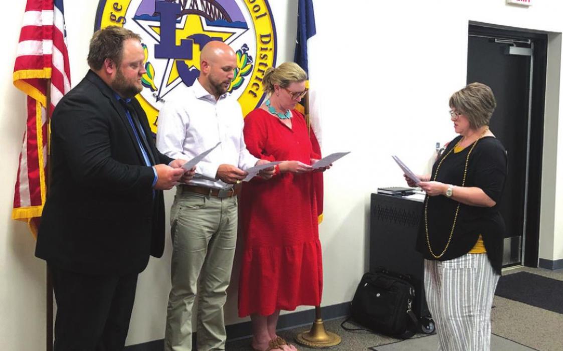 Incoming LGISD school board members, left to right, Anthony Wessels, Dr. Travis Ulrich and Mary Gunn take their oath of office from board secretary Tina Huenefeld Monday. Wessels and Ulrich each won three-person races to claim new seats on the board. Gunn was an incumbent and ran unopposed.