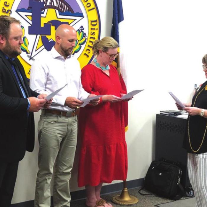Incoming LGISD school board members, left to right, Anthony Wessels, Dr. Travis Ulrich and Mary Gunn take their oath of office from board secretary Tina Huenefeld Monday. Wessels and Ulrich each won three-person races to claim new seats on the board. Gunn was an incumbent and ran unopposed.