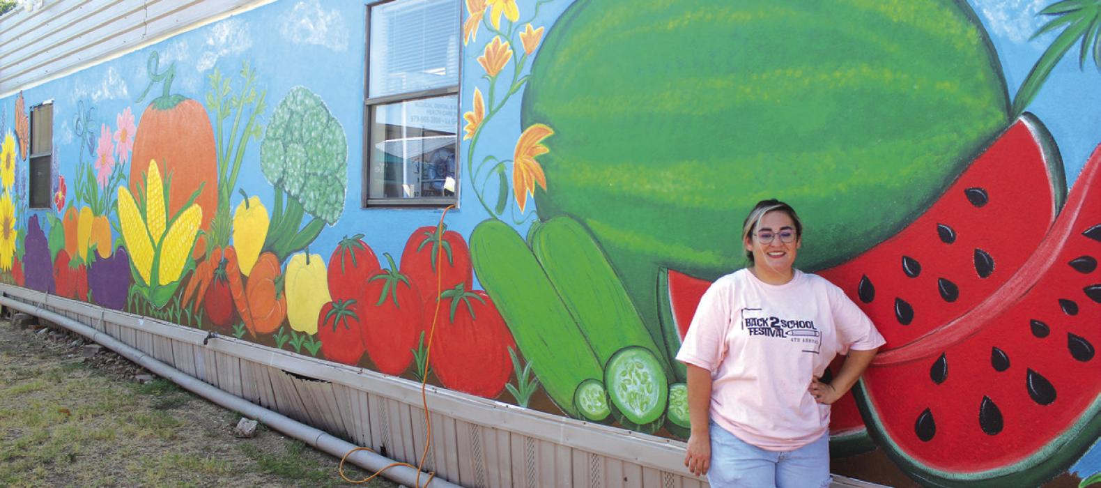 Juanita Navarro stands next to the mural she painted in the Tejas Clinic community garden, site of Saturday’s festival. Photos by Jeff Wick