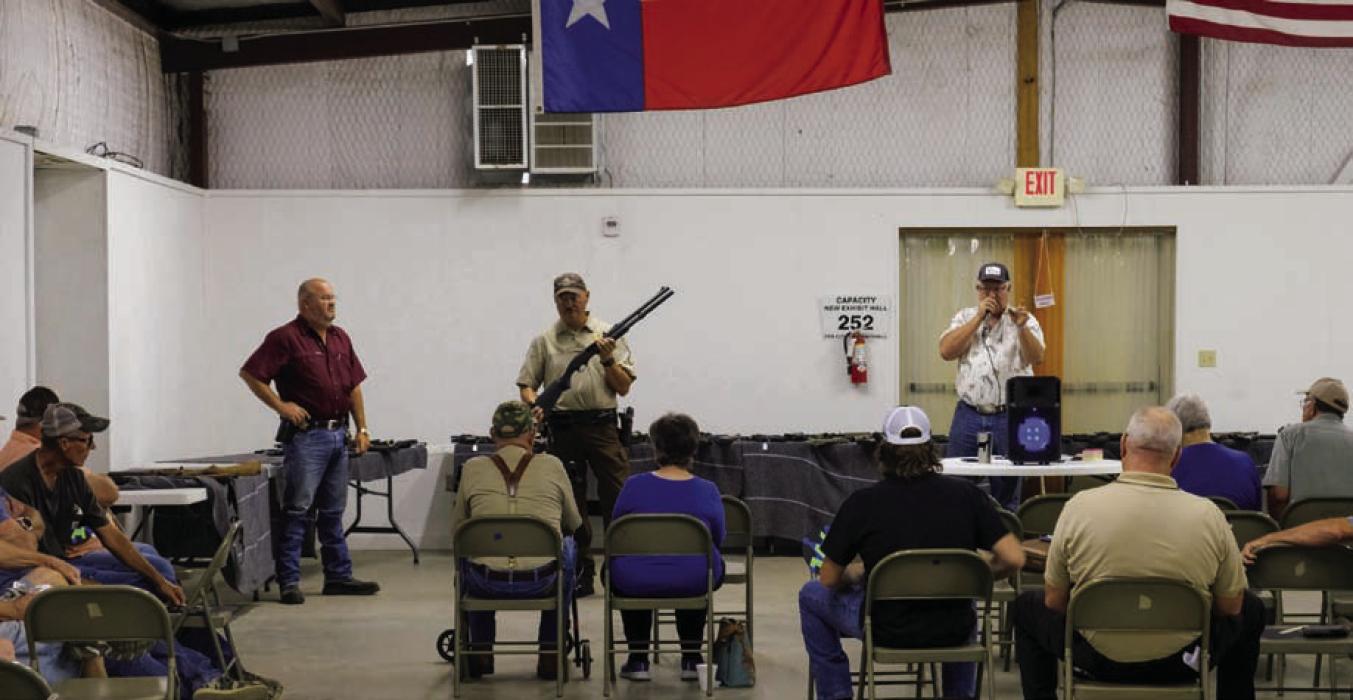 Sgt. Ron Naumann holds a 12 gauge Remington 870 shotgun as auctioneer Lee Fritsch (right) calls out the bids at a gun auction hosted by The Fayette County Sheriff’s Office on Thursday, Sept. 28. The Sheriff’s auction included more than 100 firearms that have been seized and forfeited in criminal cases. The auction raised about $32,000 that will be used to supplement the Sheriff’s Office budget. Photo by Andy Behlen