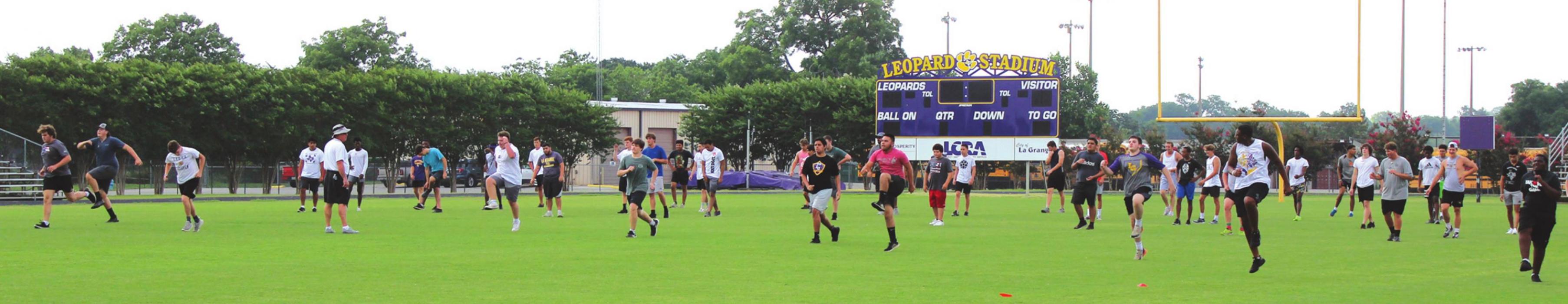 La Grange high school football players go through stretching drills Tuesday morning at Leopard Stadium. Photo by Jeff Wick