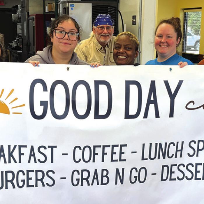 In the midst of a trial run of lunch service Wednesday, the employees of Good Day Cafe in La Grange posed with a sign that was placed outside the business Friday. The new cafe is now open for lunch in the old Hank’s Express spot at 154 S. Jefferson Street. They plan to add breakfast service soon. Photo by Jeff Wick